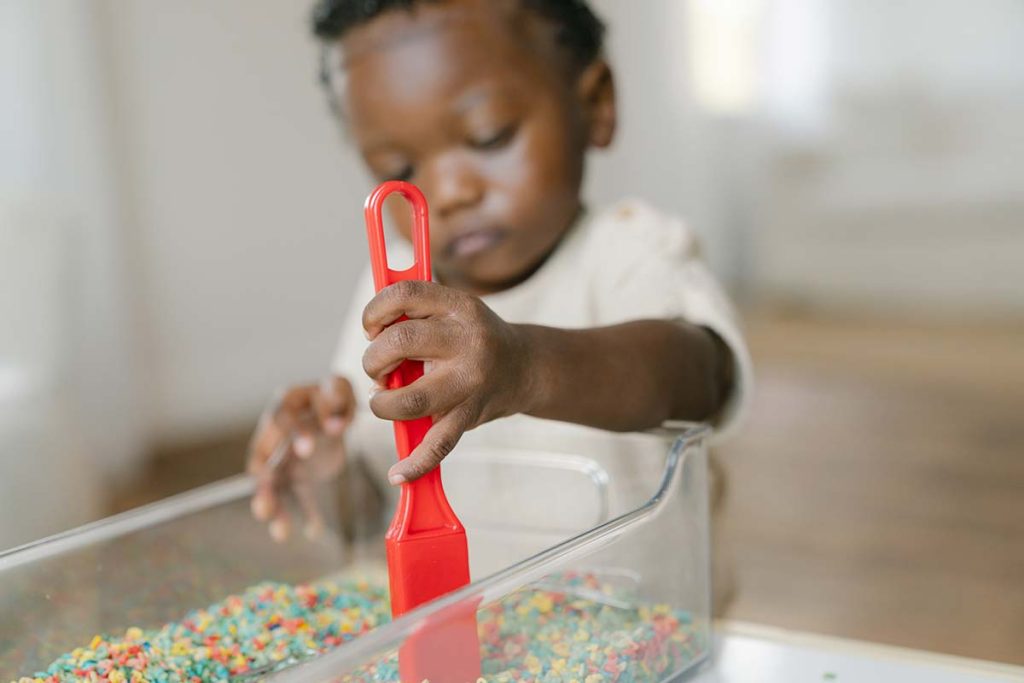 Boy Playing with Red Shovel
